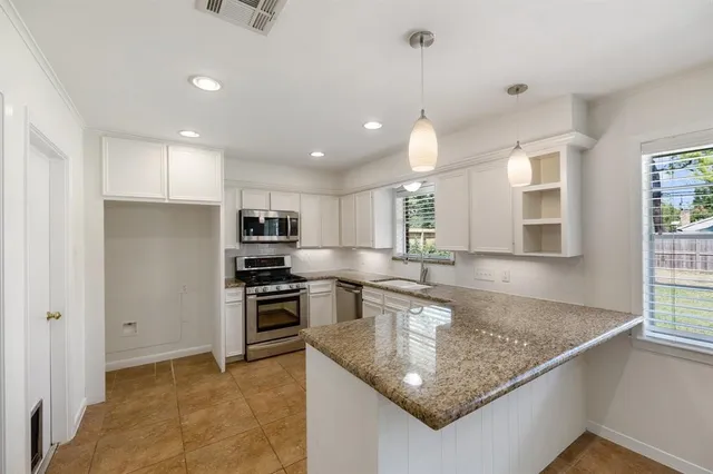 a kitchen with kitchen island a counter top space stainless steel appliances and cabinets