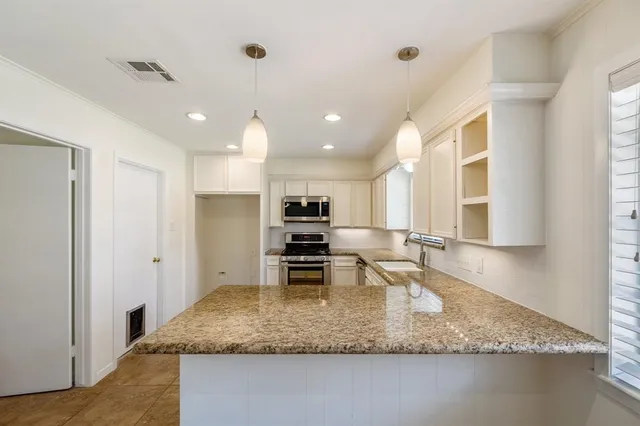 a kitchen with kitchen island a sink and a counter top space