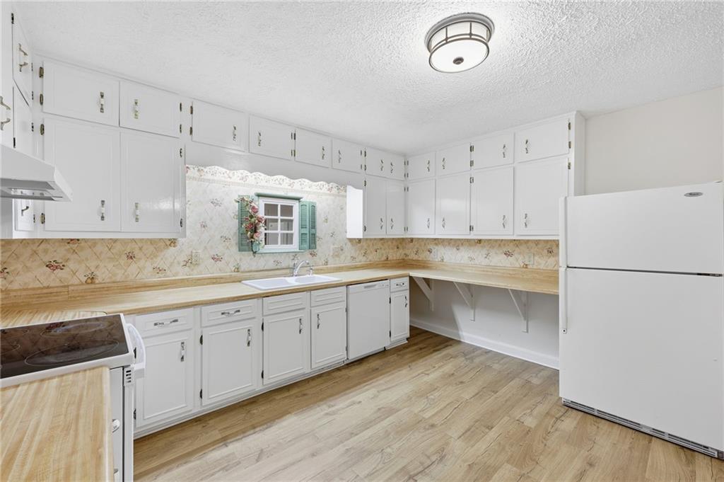 1304 Pine Valley Road Gainesville, GA 30501 - Photo 11 of 30 a kitchen with cabinets wooden floor and stainless steel appliances