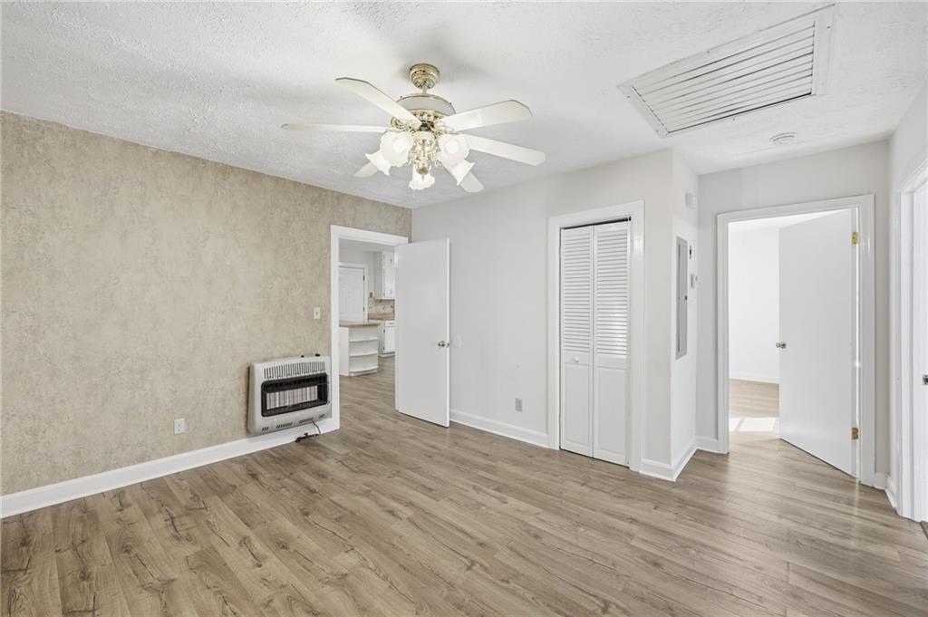 1304 Pine Valley Road Gainesville, GA 30501 - Photo 15 of 30 an empty room with wooden floor chandelier fan and windows