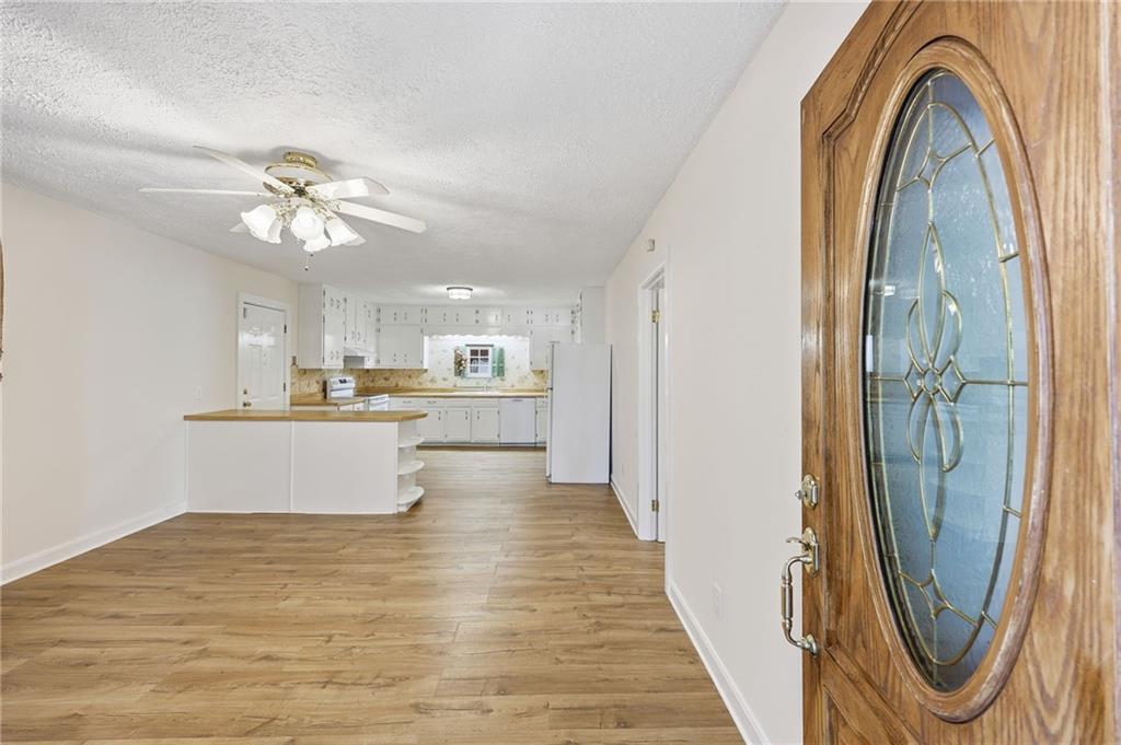 1304 Pine Valley Road Gainesville, GA 30501 - Photo 5 of 30 a view of a kitchen with kitchen island a refrigerator a sink dishwasher a dining table and chairs with wooden floor