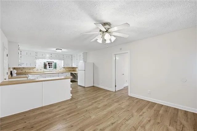 a kitchen with stainless steel appliances granite countertop a sink cabinets and wooden floor