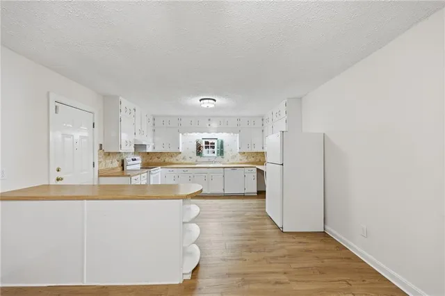 a view of kitchen with refrigerator stove and oven