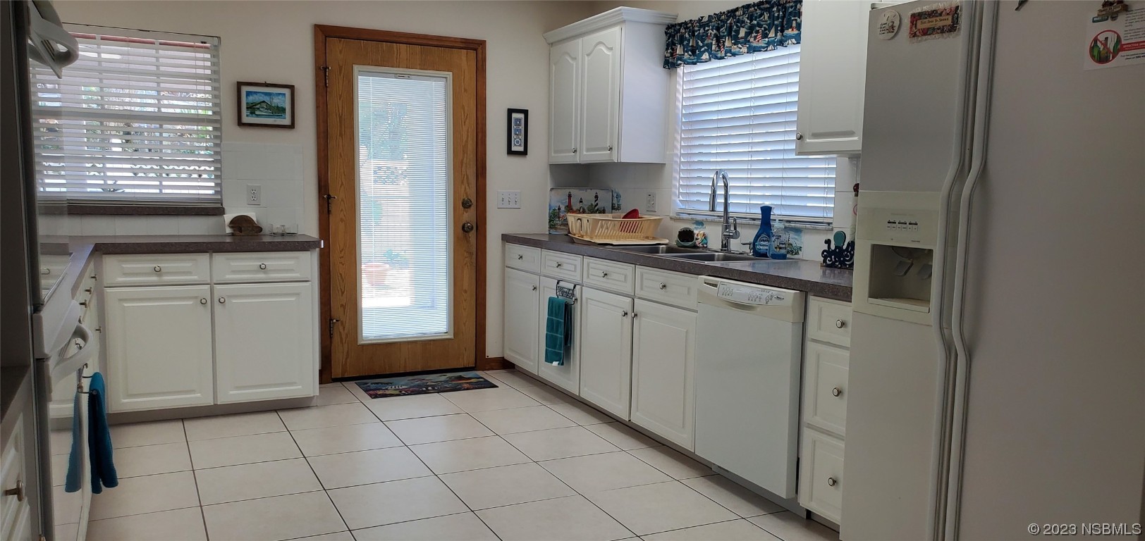 239 Kirkland Road New Smyrna Beach, FL 32169 - Photo 18 of 36 a kitchen with stainless steel appliances granite countertop a refrigerator and a sink