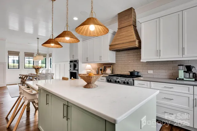 a kitchen with stainless steel appliances granite countertop a sink a stove and white cabinets