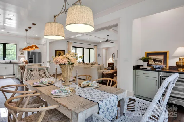 a view of a dining room with furniture a kitchen and chandelier