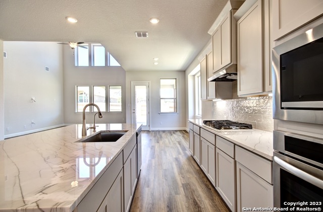 6825 Hallie Loop Schertz, TX 78154 - Photo 1 of 1 a kitchen with granite countertop stainless steel appliances and view living room