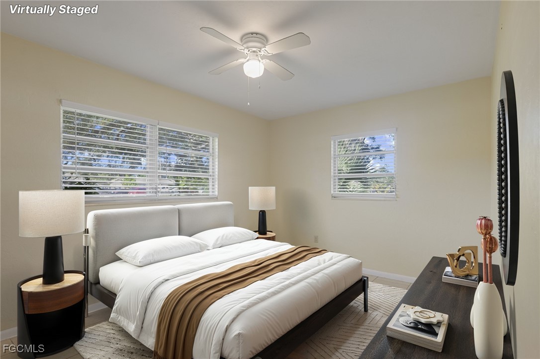 112 Clayton Avenue Lehigh Acres, FL 33936 - Photo 12 of 21 a bedroom with a bed and a chandelier