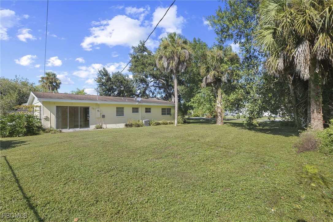 112 Clayton Avenue Lehigh Acres, FL 33936 - Photo 15 of 21 a front view of a house with a garden