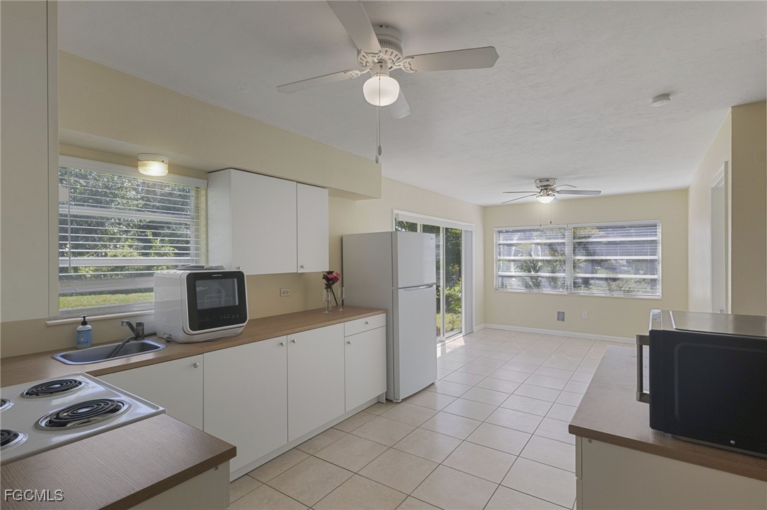 112 Clayton Avenue Lehigh Acres, FL 33936 - Photo 6 of 21 a kitchen with stainless steel appliances a stove sink and microwave