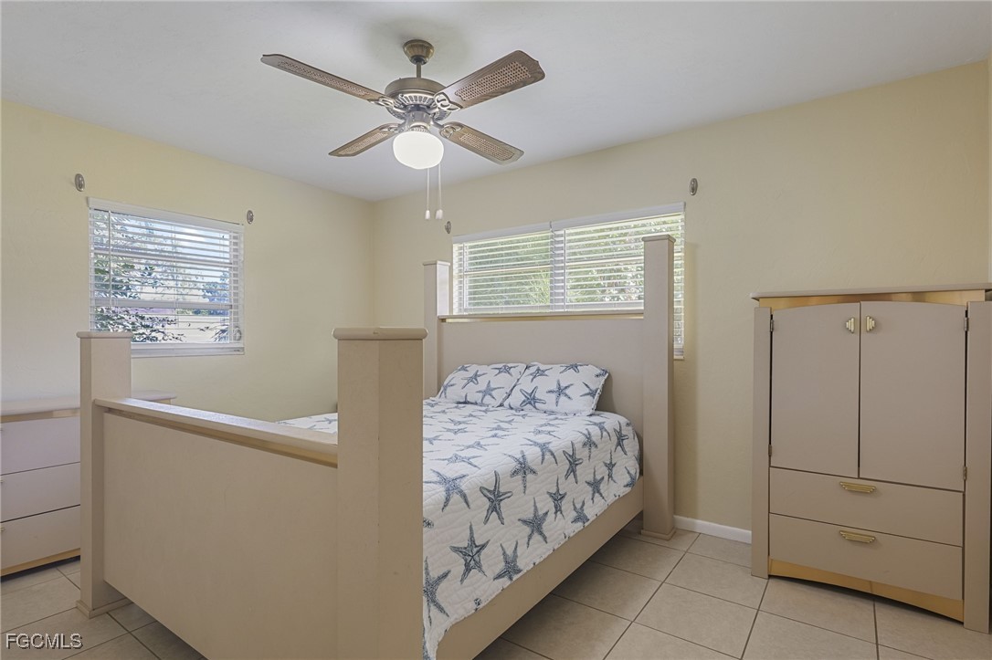 112 Clayton Avenue Lehigh Acres, FL 33936 - Photo 10 of 21 a bedroom with a bed and a chandelier