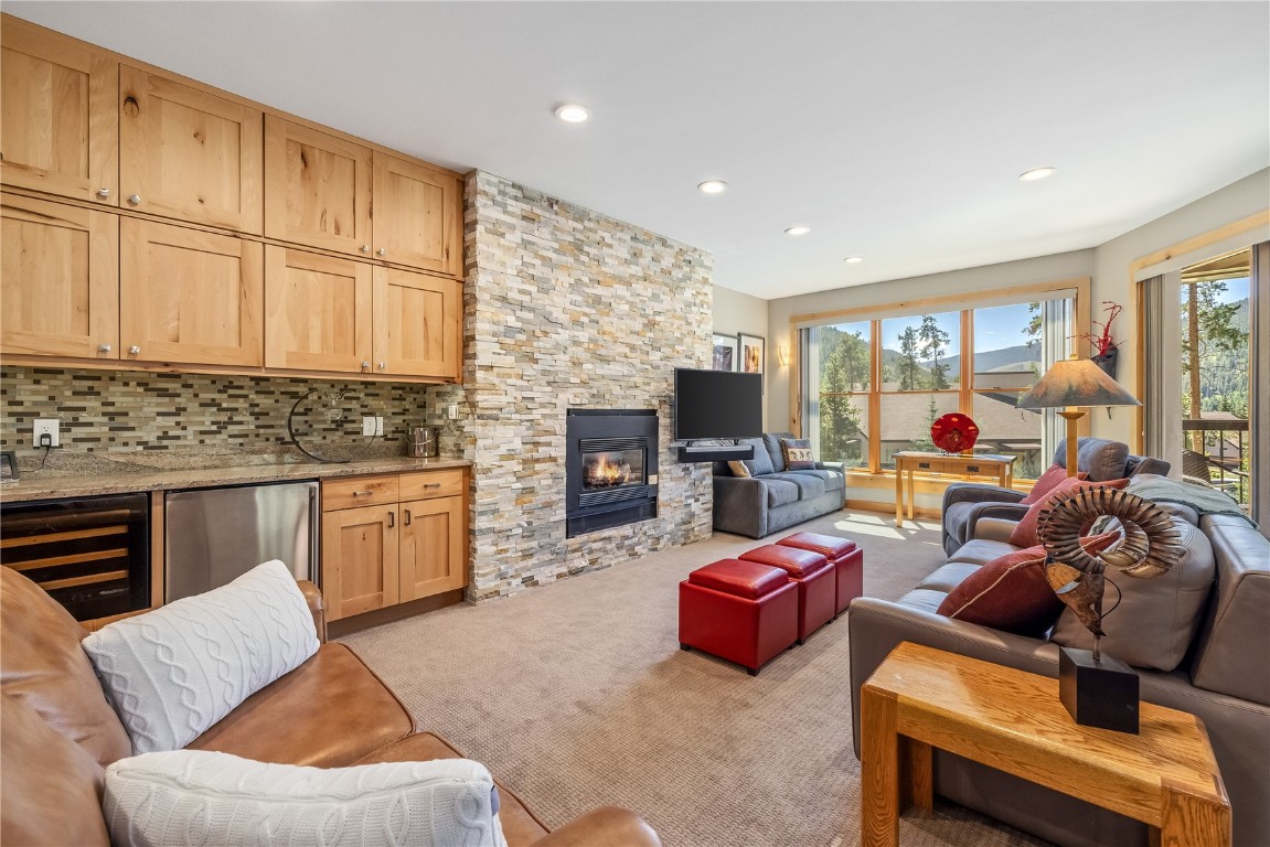 180 Tennis Club Road, Unit 1636 Keystone, CO 80435 - Photo 1 of 34 Carpeted living room with a wealth of natural light, wine cooler, and a stone fireplace