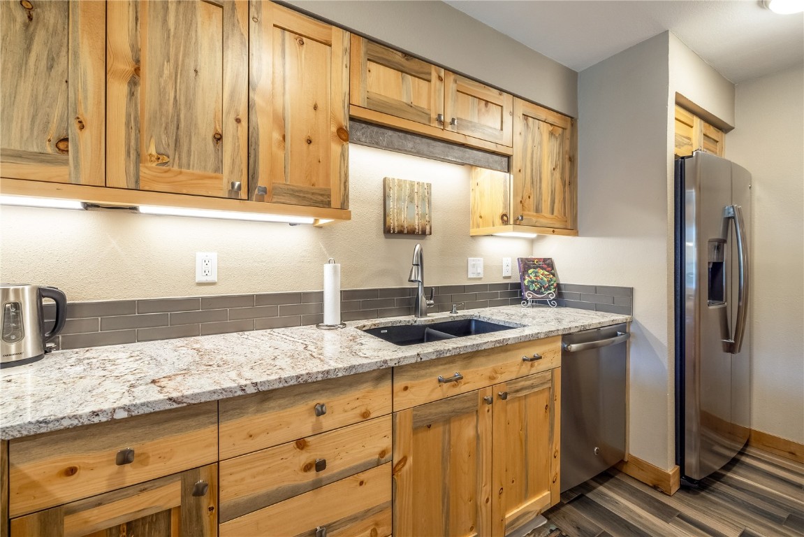 180 Tennis Club Road, Unit 1636 Keystone, CO 80435 - Photo 11 of 34 Kitchen with stainless steel appliances, light stone counters, sink, and dark hardwood / wood-style floors