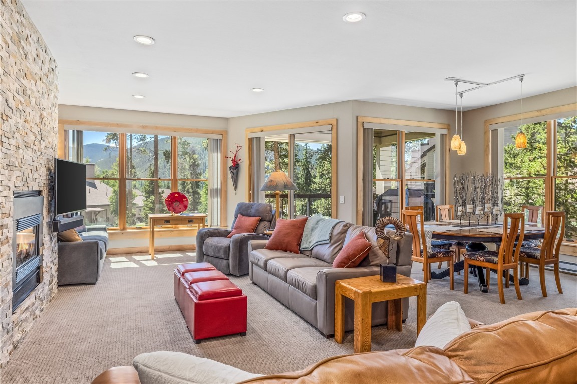 180 Tennis Club Road, Unit 1636 Keystone, CO 80435 - Photo 2 of 34 Carpeted living room with track lighting, a fireplace, and a healthy amount of sunlight