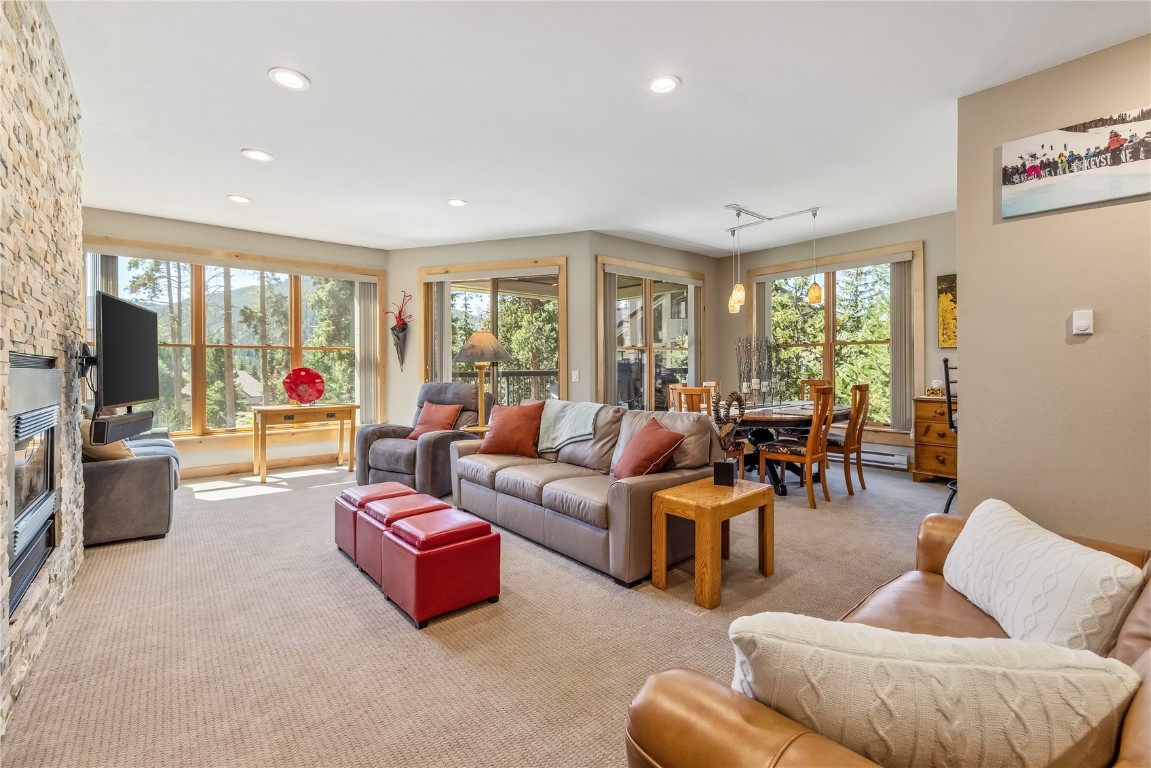180 Tennis Club Road, Unit 1636 Keystone, CO 80435 - Photo 4 of 34 Living room featuring a stone fireplace, rail lighting, plenty of natural light, and carpet floors