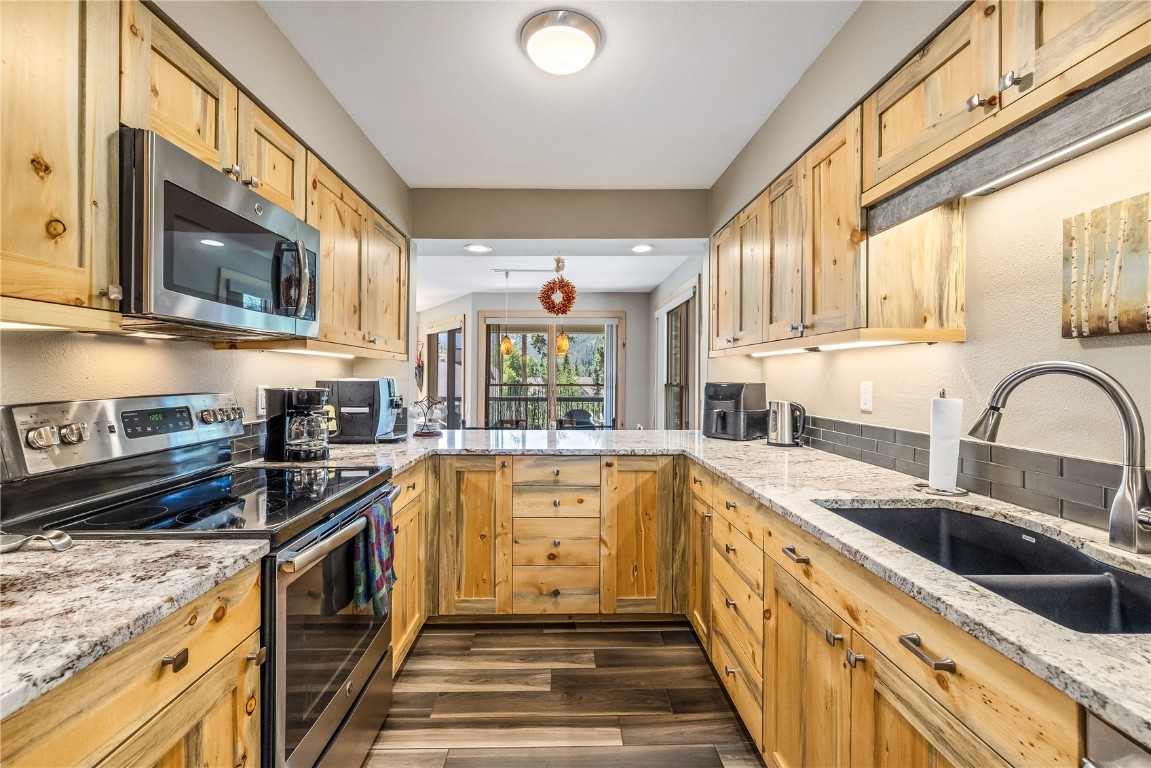 180 Tennis Club Road, Unit 1636 Keystone, CO 80435 - Photo 10 of 34 Kitchen featuring light stone countertops, stainless steel appliances, sink, and dark hardwood / wood-style floors