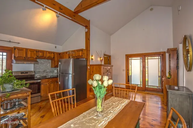 a living room with furniture a large window and wooden floor