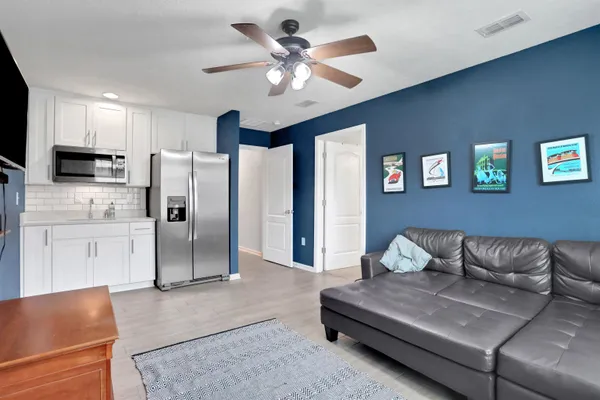 a living room with stainless steel appliances kitchen island granite countertop furniture and a view of kitchen