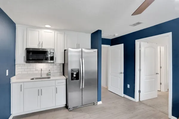 a kitchen with stainless steel appliances a refrigerator sink and microwave