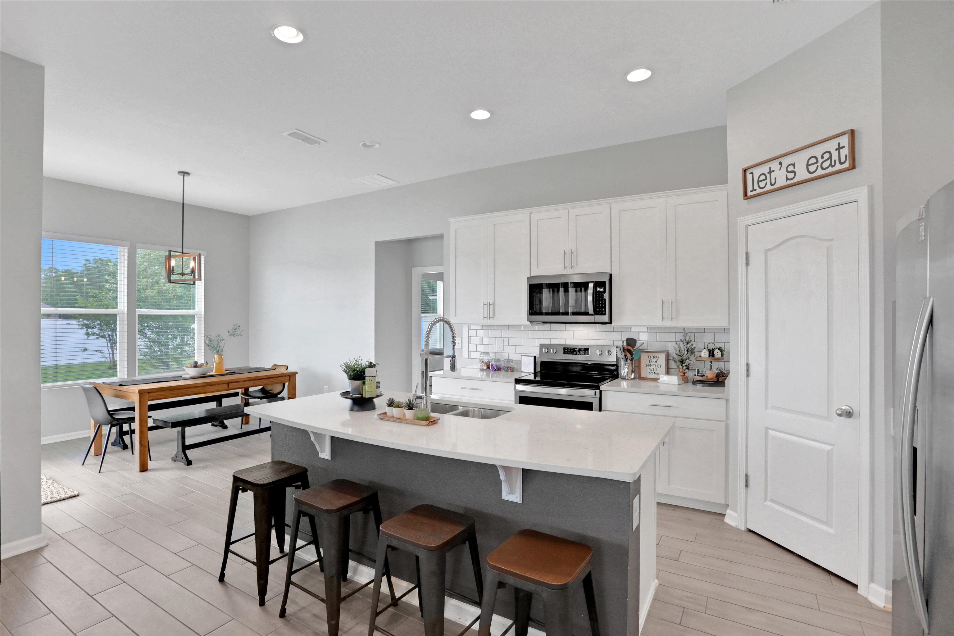 123 Hickory Ridge Road St. Augustine, FL 32084 - Photo 3 of 26 a kitchen with a dining table chairs and refrigerator