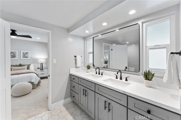 a bathroom with a granite countertop sink a mirror a vanity and shower