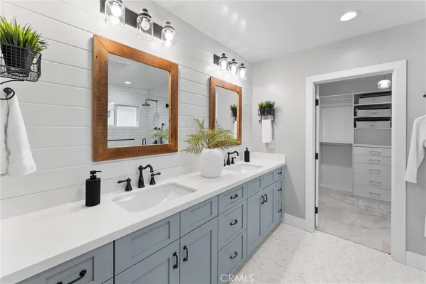 a bathroom with a double vanity sink mirror and shower