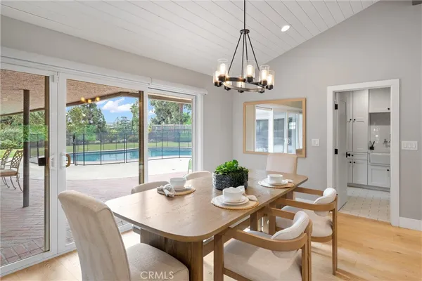 a dining room with furniture a chandelier and wooden floor