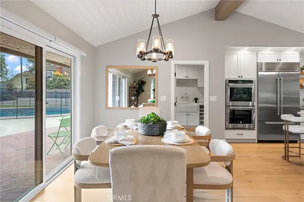 a kitchen with stainless steel appliances kitchen island granite countertop a sink a microwave a refrigerator and white cabinets