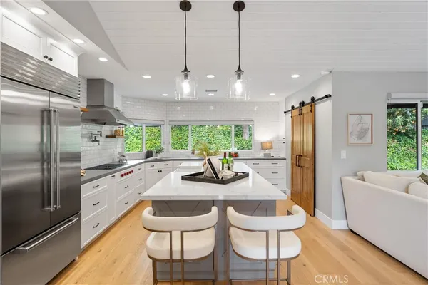 a kitchen with a sink a stove a refrigerator cabinets and a window