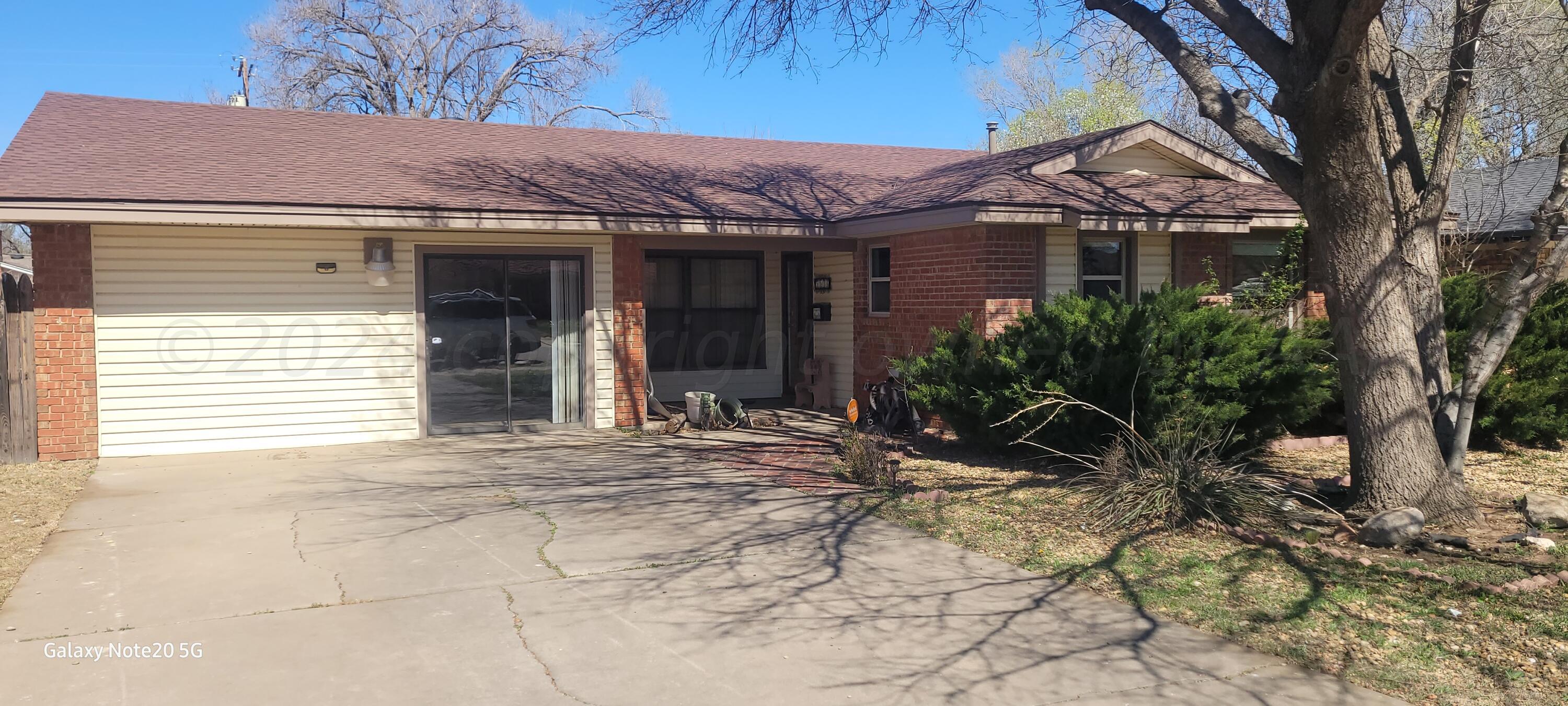 a view of a house with a yard and tree