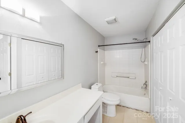 a bathroom with a granite countertop sink mirror vanity and toilet