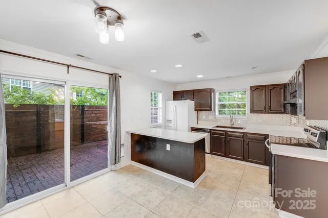 a large kitchen with kitchen island a sink stainless steel appliances and cabinets
