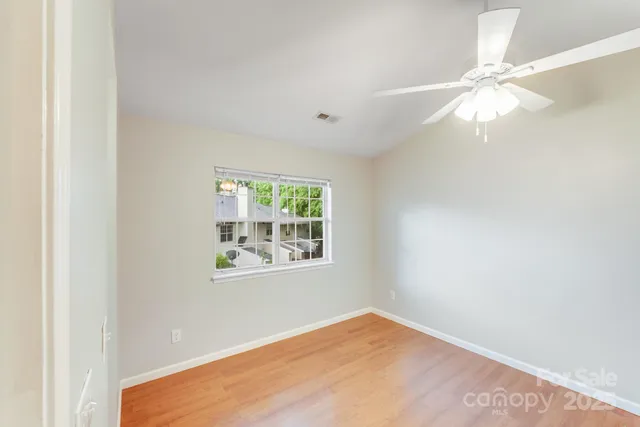 an empty room with a window and a fan