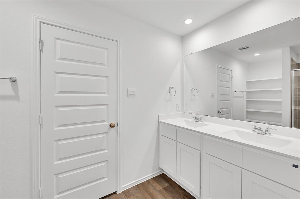 31006 Brightwell Bend Fulshear, TX 77441 - Photo 16 of 47 a bathroom with a double vanity sink and mirror