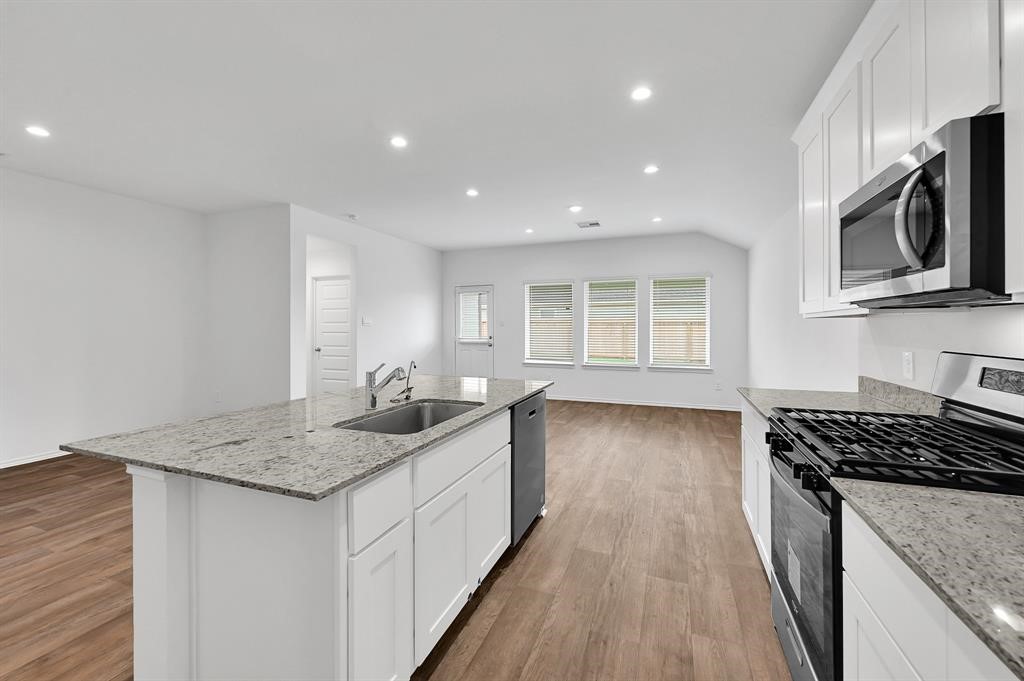 31006 Brightwell Bend Fulshear, TX 77441 - Photo 4 of 47 a kitchen with granite countertop counter space a sink and appliances