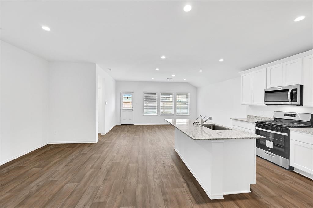 31006 Brightwell Bend Fulshear, TX 77441 - Photo 6 of 47 a kitchen with stainless steel appliances a stove top oven a sink and a microwave