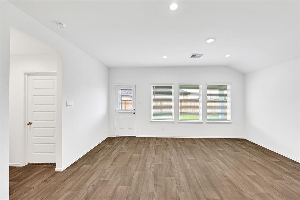 31006 Brightwell Bend Fulshear, TX 77441 - Photo 7 of 47 an empty room with wooden floor and windows