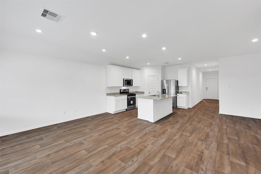 31006 Brightwell Bend Fulshear, TX 77441 - Photo 8 of 47 a open kitchen with white cabinets and wooden floor
