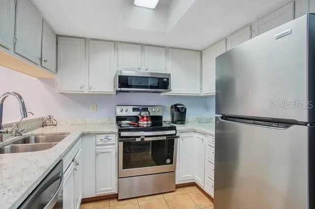 a kitchen with granite countertop a sink and stove top oven