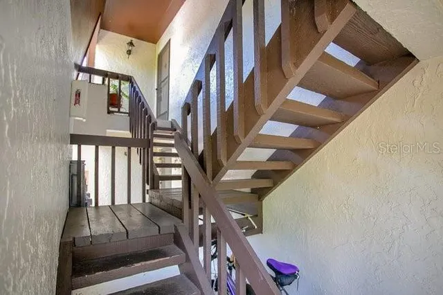 a view of staircase with lots of frames on wall and stairs