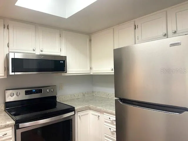 a kitchen with stainless steel appliances a refrigerator stove and microwave