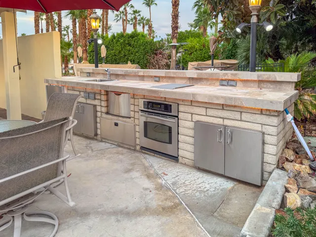 a view of a patio with table and chairs under an umbrella