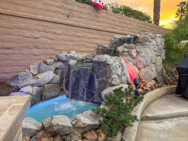 a view of a patio with table and chairs under an umbrella