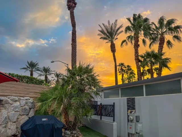 a view of a patio with a table and chairs under an umbrella