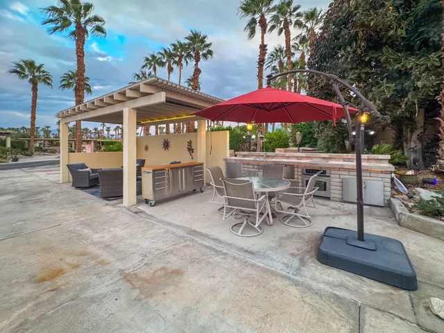 a view of a patio with a table and chairs under an umbrella