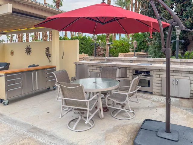 a patio with a table and chairs under an umbrella