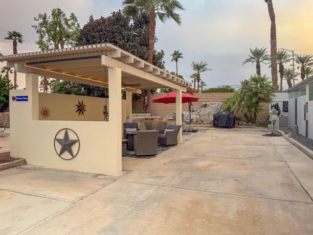 a view of a patio with a table and chairs under an umbrella