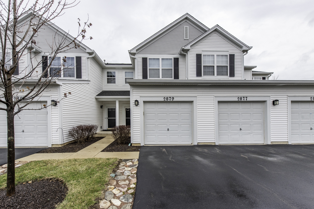 2879 Falling Waters Drive, Unit 2879 Lindenhurst, IL 60046 - Photo 1 of 30 a front view of a house with a yard and garage