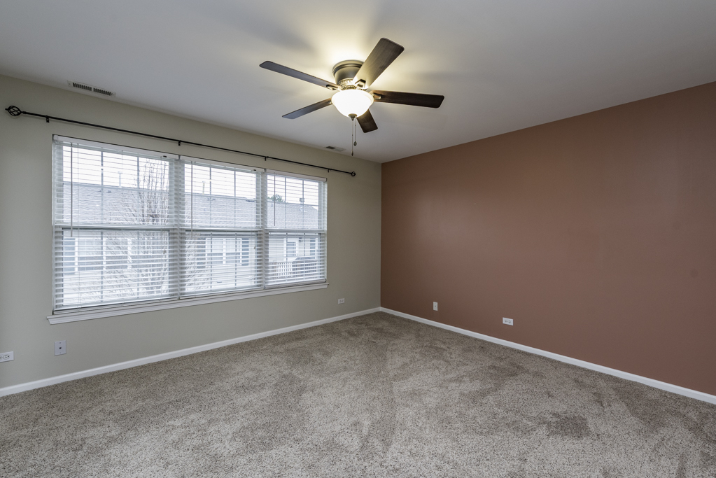 2879 Falling Waters Drive, Unit 2879 Lindenhurst, IL 60046 - Photo 15 of 30 an empty room with window and ceiling fan