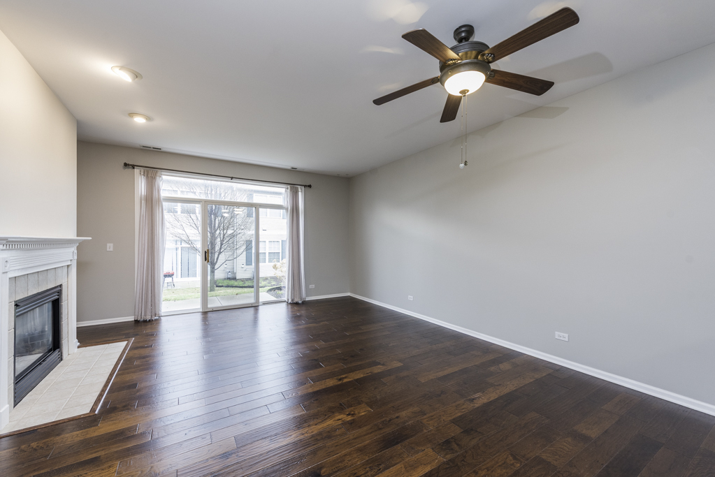 2879 Falling Waters Drive, Unit 2879 Lindenhurst, IL 60046 - Photo 2 of 30 wooden floor in an empty room with a window